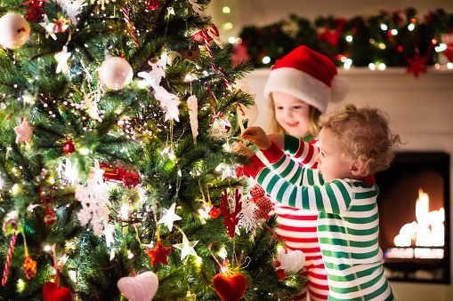 childs decorating a christmas tree